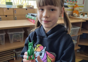 Dziewczynka pozuje do zdjęcia z klockami Lego