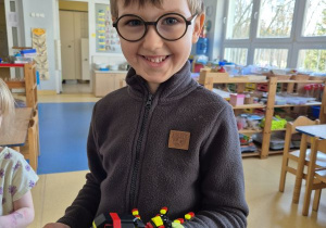Chłopiec pozuje do zdjęcia z klockami Lego