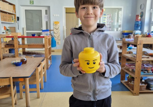 Chłopiec pozuje do zdjęcia z klockami Lego