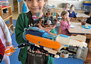 Chłopiec pozuje do zdjęcia z klockami Lego