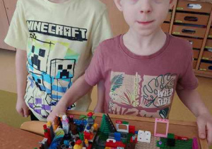 Natan i Tytus prezentują ułożoną według własnego pomysłu budowlę z klocków Lego