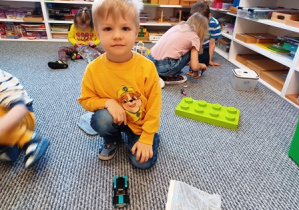 Jaś prezentuje swoje auto złożone z klocków Lego