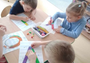 Dzieci wyklejają plasteliną literki