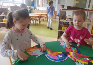 Dzieci wykonują papierową papugę z talerzyków