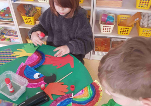 Dzieci wykonują papierową papugę z talerzyków