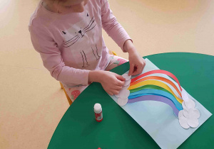 Dziewczynka wykonuje tęczę z pasków papieru