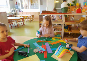 Dzieci wykonują tęczę z pasków papieru