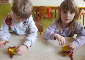 Dzieci ozdabiają kurki piórkami