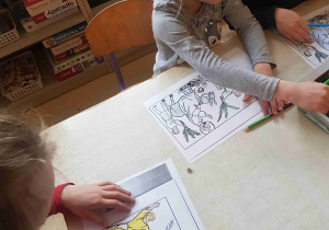 Dzieci kolorują kartę pracy w nawiązaniu do Niedzieli Palmowej