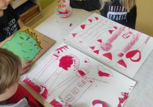 Dzieci wykonują prace plastyczne na temat barw narodowych.