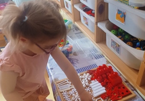 Julcia układa klocki w kolorach flagi Polski