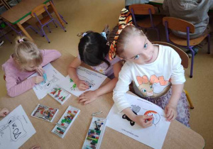 Dziewczynki podczas kolorowania karty pracy na temat mycia rąk