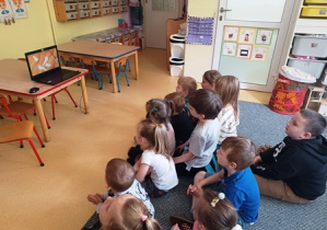 Dzieci słuchają i oglądają prezentację do piosenki "Nie siej paniki..."