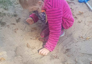 Dziewczynka bawi się w piasku