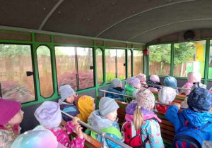 Dzieci siedzą w wagoniku kolejki