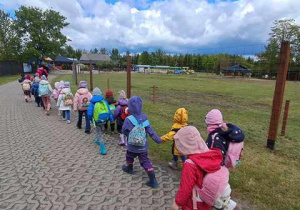Grupa zielona spaceruje w parach po ogrodzie zoologicznym w Borysewie