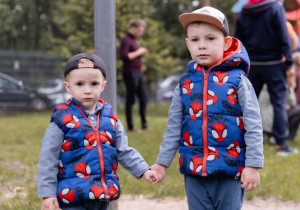 Dwóch chłopców stoi trzymając się za rękę