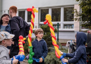 Trzech chłopców prezentuje karabiny wykonane z balonów