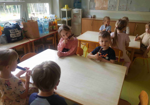 Dzieci jedzą lody podarowane przez Rodziców z grupy IV