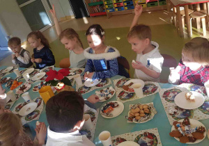 Dzieci siedzą przy wspólnym wigilijnym stole