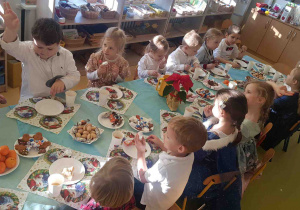 Dzieci częstują się smakołykami na świątecznym stole