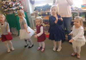 Dzieci w kręgu śpiewają przygotowane na występ piosenki świąteczne