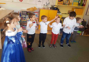 Dzieci uroczyście ubrane tańczą w kole