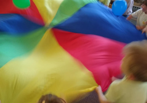 Dzieci bawią się chustą animacyjną i balonami
