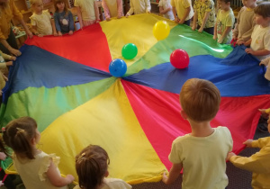 Dzieci bawią się chustą animacyjną i balonami