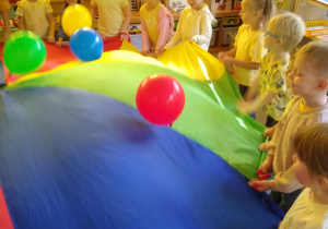 Dzieci bawią się chustą animacyjną i balonami