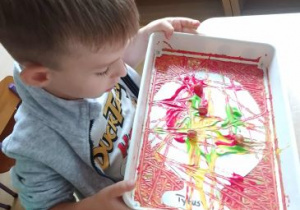 Chłopiec koloruje balon wycięty z papieru
