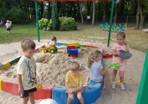 Dzieci bawią się w piaskownicy.
