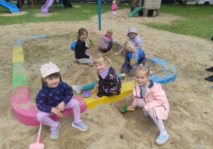 Dzieci bawią się w piaskownicy.