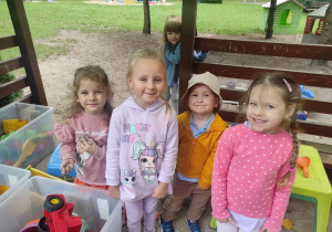 Uśmiechnięte dzieci w altanie.