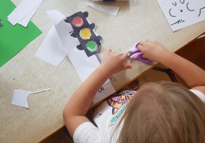 Dziewczynka wycina sygnalizator świetlny z papieru