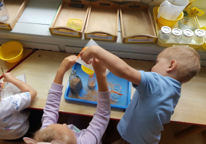 Dzieci przesypują piasek
