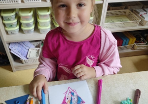 Maja odrysowywuje figury geometryczne.