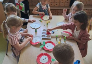 Dzieci podczas wykonywania pracy plastycznej przedstawiającej jabłka