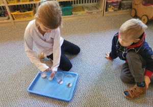 Dziewczynka miesza sodę z barwnikiem