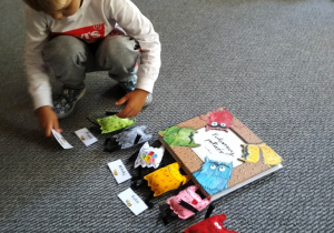 Zachary kładzie wizytówkę przy potworku oznaczającym spokój