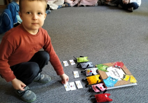 Marcel kładzie wizytówkę przy potworku oznaczającym radość