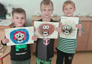 Chłopcy pozują do zdjęcia z wykonaną przez siebie pracą plastyczną pt. "Potworek pełen emocji"