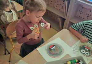 Dziewczynka wycina elementy do swojej kompozycji przestawiającej "Potworka pełnego emocji"