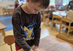 Chłopiec nakleja naklejkę określającą jego nastrój na swoją wizytówkę