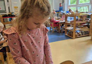 Dziewczynka nakleja naklejkę określającą jej nastrój na swoją wizytówkę