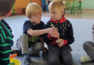 Chłopcy podają sobie czosnek z rąk do rąk