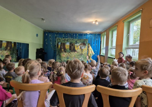 Dzieci siedzą na widowni i oglądają przedstawienie