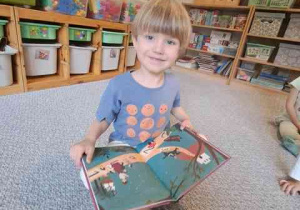 Chłopiec ogląda książeczkę o Marii Montessori