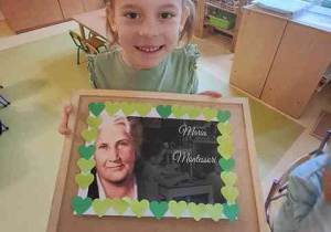 Tosia prezentuje wykonaną przez siebie ramkę z elementów kolorowego papieru do portretu Marii Montessori