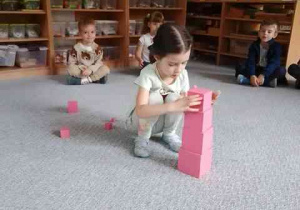 Nina dokłada element różowej wieży do kompozycji